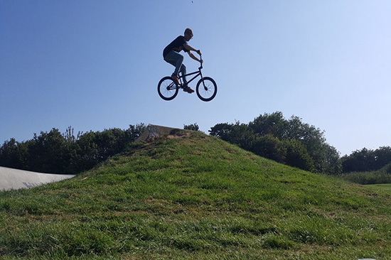 BMX Jumping a grass hill action shot